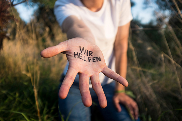 eine Hand mit der Aufschrift wir wollen helfen