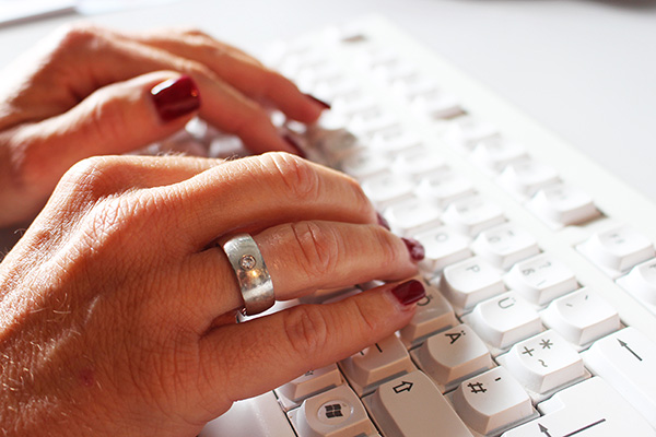 Frauenhände auf einer Computer-Tastatur.