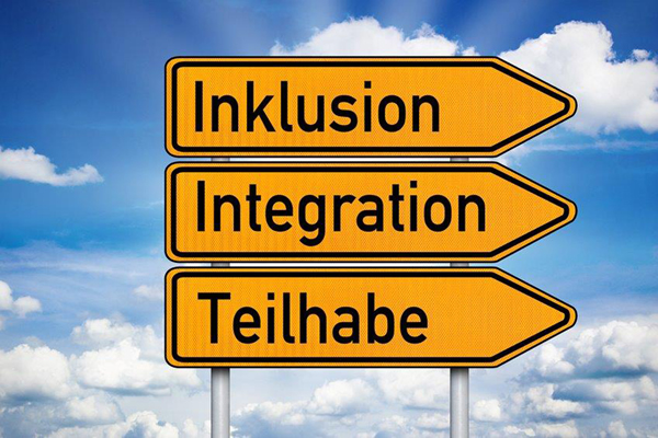 mehrere Wegweiser mit den Aufschriften Inklusion, Integration und Teilhabe