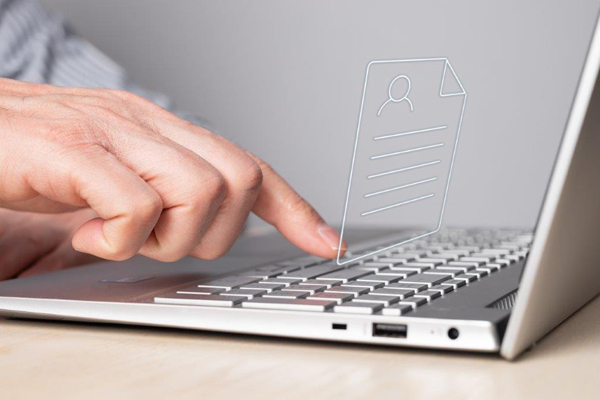 die Hand eines Mannes über der Tastatur eines Laptops, über dem ein gezeichnetes Onlineformular schwebt