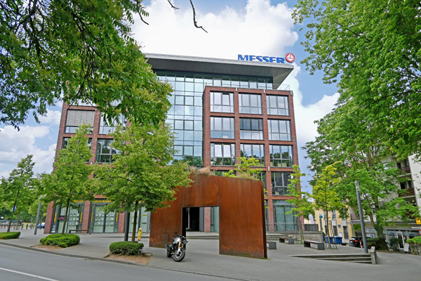 ein Bürogebäude an einer mit Bäumen gesäumten Straße