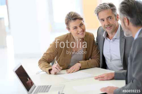 zwei Männer und eine Frau am Laptop im Gespräch.