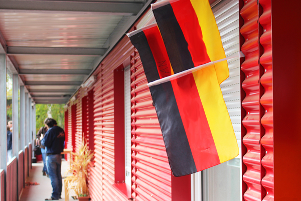 a German flag on the wall, in the background is a man