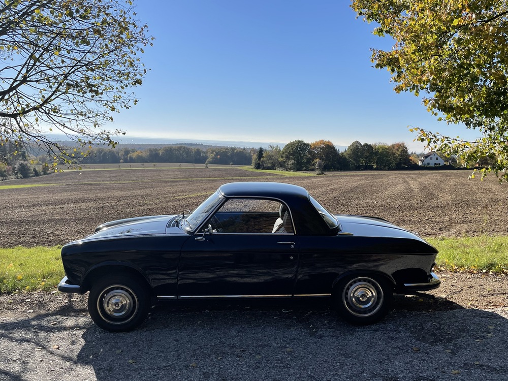 Dunkles Auto vor einem Feld