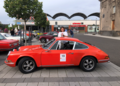 Rotes Auto steht auf einem Parkplatz, dahinter steht eine lächelnde Frau | Copyright: Teilnehmer Rotes Auto steht auf einem Parkplatz, dahinter steht eine lächelnde Frau
