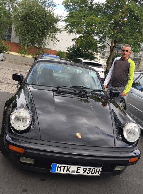 Schwarzes Auto auf einem Parkplatz, rechts davon steht ein Mann | Copyright: Teilnehmer Schwarzes Auto auf einem Parkplatz, rechts davon steht ein Mann
