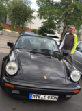 Schwarzes Auto auf einem Parkplatz, rechts davon steht ein Mann | Copyright: Teilnehmer Schwarzes Auto auf einem Parkplatz, rechts davon steht ein Mann