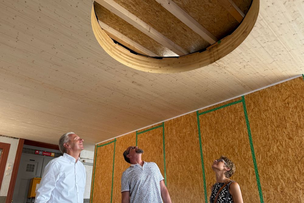 Drei Menschen, die in die Höhe auf einer Baustelle die Decke anschauen