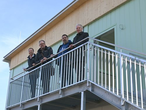Gruppenfoto vor Erweiterungsbau Taunusblickschule, vier Männer
