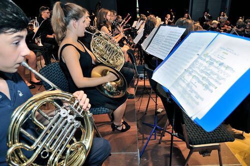 Nahaufnahme eines Sinfonieorchesters mit Notenblättern und Instrumenten
