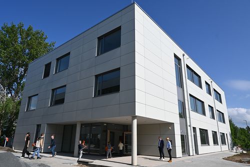 das neue Schulgebäude der Otfried-Preußler-Schule mit Schülern davor
