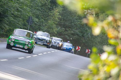 mehrere Oldtimer Autos auf einer Straße
