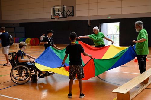 Menschen mit einem Tuch in einer Turnhalle
