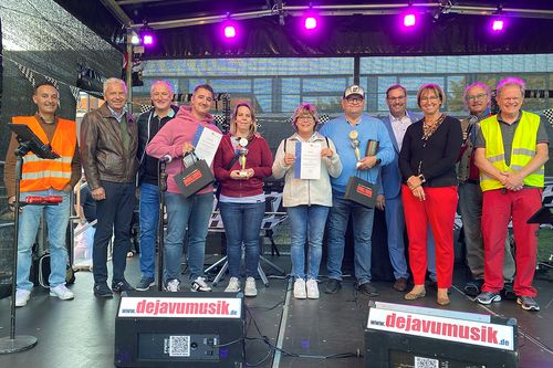 Gruppenbild der Siegerehrung der Main-Taunus-Rallye auf einer Bühne
