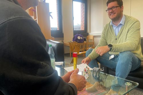 Das Bild zeigt einen Pflegevater im Gespräch mit Daniel Klein vom Jugendamt.
