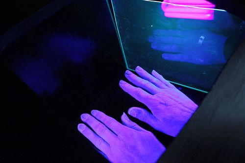 lila Hände im Schwarzlicht
