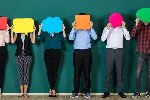 Menschen, die bunte Papier Sprechblasen vor Ihre Gesichter halten
