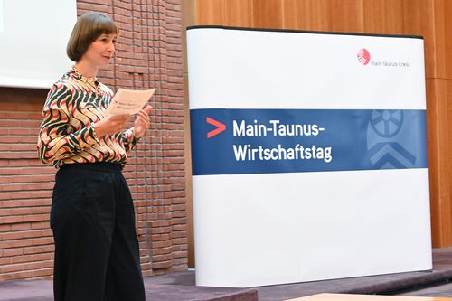 Ein Symbolbild vom Main-Taunus-Wirtschaftstag 2024: Zu sehen ist eine Moderatorin auf einer Bühne, die durch die Veranstaltung führt
