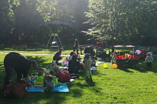 Kleinkinder mit Betreuern machen ein Picknick im Park
