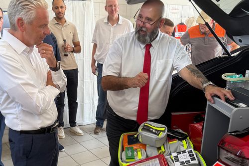 Zwei Männer schauen sich ein Rettungsfahrzeug an
