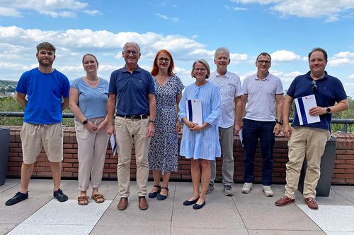 Ein Gruppenfoto mit mehren Menschen vor dem Landratsamtgebäude

