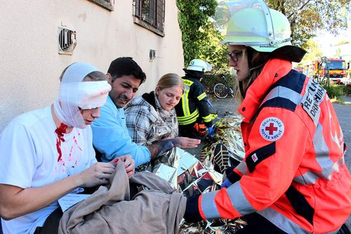 Verletze Personen werden von einer Rettungssanitäterin behandelt
