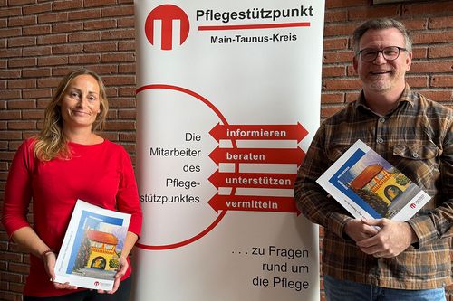 Zwei Personen halten Broschüren in den Händen
