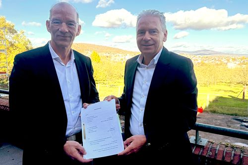 Zwei Menschen halten einen Vertrag in Ihren Händen
