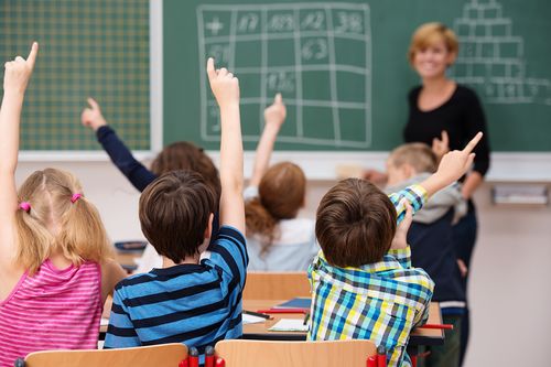 Schülerinnen und Schüler mit Blick auf die Tafel in der Schule

