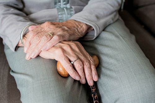 Hände einer Senioren auf dem Schoß liegend
