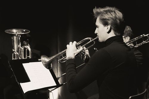 Ein junger Mann spielt ein Blasinstrument
