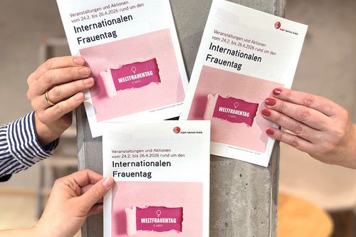 Drei Frauen halten das Programmheft in ihren Händen
