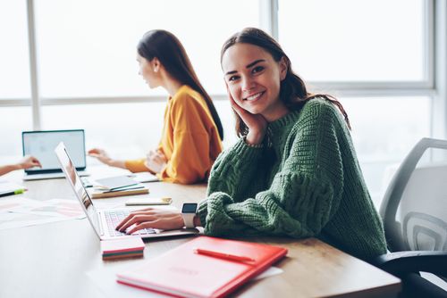 Zwei junge Frauen sitzen an einem Schreibtisch und arbeiten