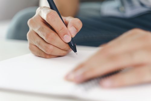 Eine Hand füllt ein Dokument aus
