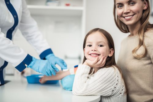 Ein Mädchen sitzt mit ihrer Mutter beim Kinderarzt