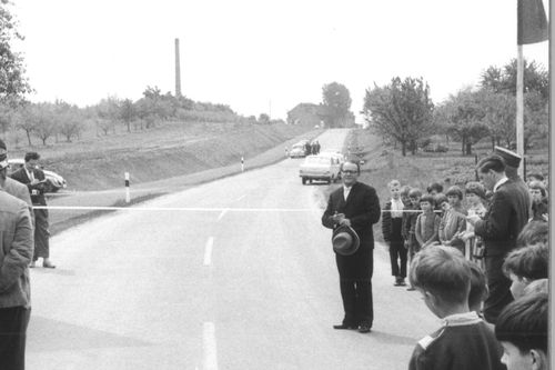 Landrat Wagenbach durchschneidet ein Eröffnungsband auf einer Straße