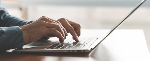 Ein Mann sitzt vor einem Laptop