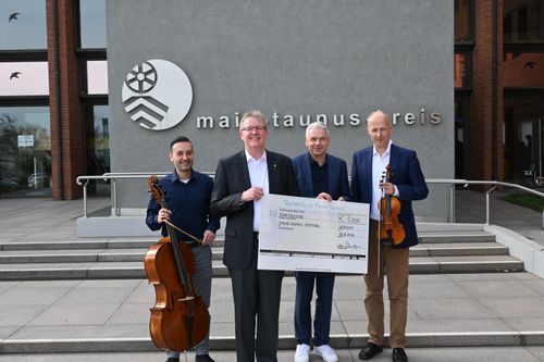 Vier Menschen mit einem Scheck in der Hand